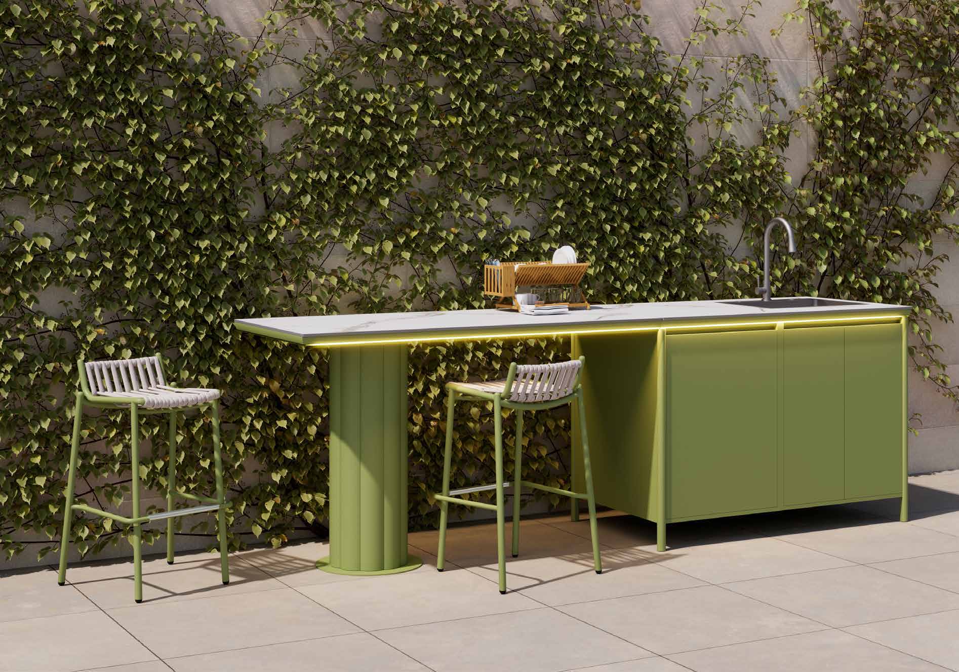 Green outdoor kitchen against a garden wall