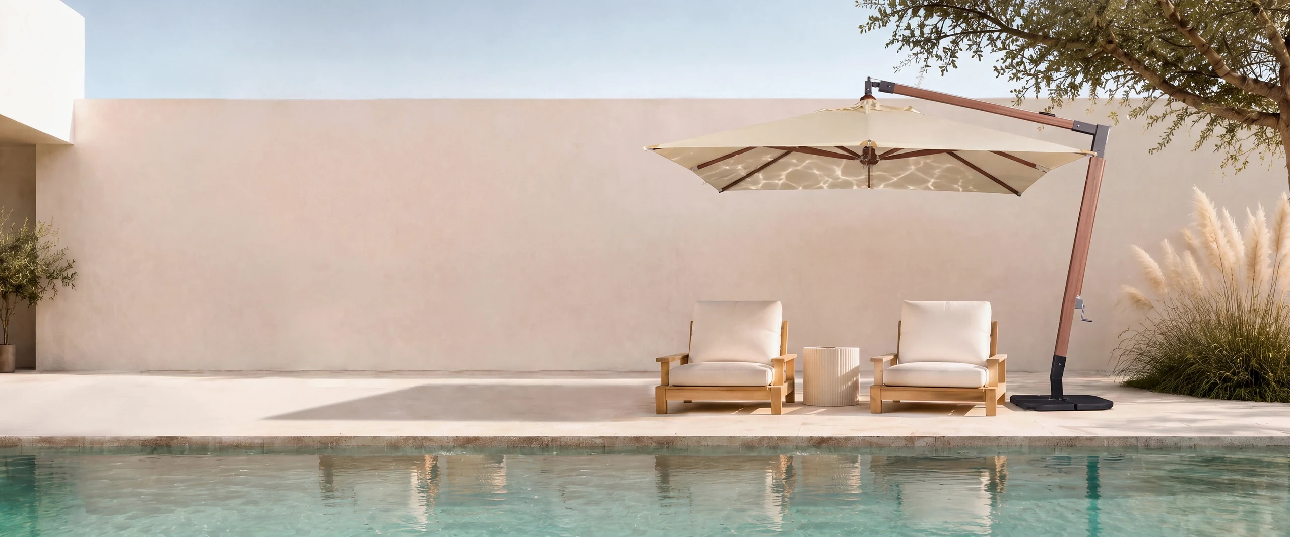 Cantilever umbrella shading two chairs beside a pool