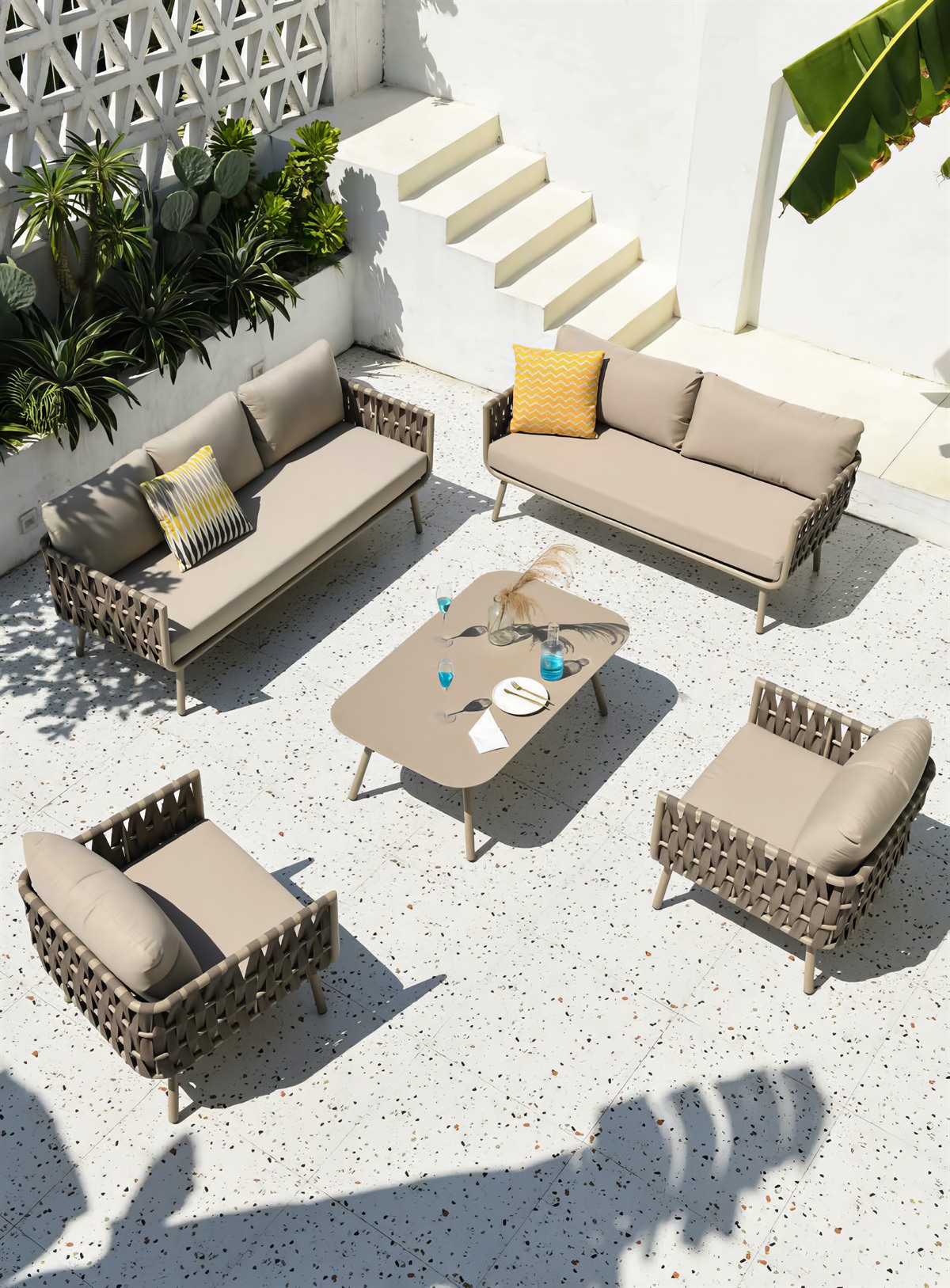 Outdoor sofa and lounge chairs arranged around a coffee table